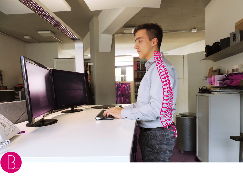 ist stehen gesünder als sitzen bild 2 Büroland junge steht am Schreibtisch Büroland